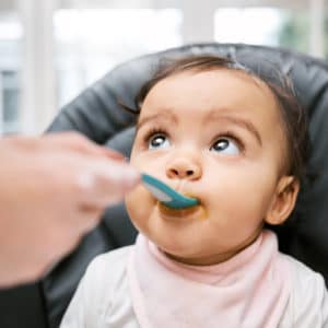 Una bambina di circa un anno viene imboccata